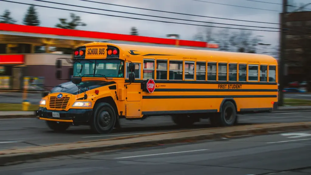 Żółty autobus szkolny w ruchu, symbolizujący pośpiech oraz codzienny stres związany z punktualnością.