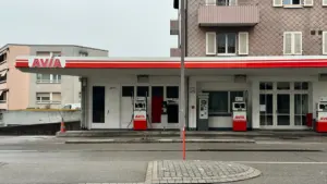 Nowoczesna stacja paliw Avia w europejskim krajobrazie, idealna ilustracja do artykułu o cenach paliw.
